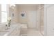 Bright bathroom featuring double sinks, a soaking tub, a glass-enclosed shower and neutral tile at 2000 Kapalua Way # 187, Durham, NC 27703