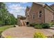 Brick home featuring a large backyard patio area surrounded by green landscaping at 2028 Pleasant Forest Way, Wake Forest, NC 27587