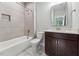 Well-lit bathroom with modern fixtures, a sleek vanity, and a combined bathtub and shower with tiled walls at 2028 Pleasant Forest Way, Wake Forest, NC 27587