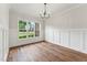 Bright, empty dining room with hardwood floors, wainscoting and a large window overlooking the neighborhood at 2028 Pleasant Forest Way, Wake Forest, NC 27587