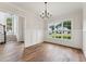 Spacious dining room with hardwood floors, wainscoting and a large window overlooking the neighborhood and a staircase beyond at 2028 Pleasant Forest Way, Wake Forest, NC 27587