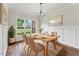 Inviting dining room with hardwood floors, wainscoting and a modern chandelier over a wooden dining table and chairs at 2028 Pleasant Forest Way, Wake Forest, NC 27587