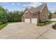 Three-car garage and extra driveway space with a basketball hoop at 2028 Pleasant Forest Way, Wake Forest, NC 27587