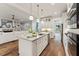 Open concept kitchen features a large island with seating, stainless steel appliances, and hardwood floors at 2028 Pleasant Forest Way, Wake Forest, NC 27587