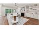 Living room featuring hardwood floors, a stone fireplace, and a large white couch next to a sliding glass door at 2028 Pleasant Forest Way, Wake Forest, NC 27587