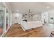 This open-concept living room features hardwood floors, a stone fireplace, and a large white couch at 2028 Pleasant Forest Way, Wake Forest, NC 27587