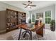 This home office features a large wooden desk and shelving, neutral walls, and large windows for plenty of natural light at 2028 Pleasant Forest Way, Wake Forest, NC 27587