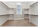 Spacious walk-in closet with built-in shelving and ample storage, illuminated by a bright window at 2028 Pleasant Forest Way, Wake Forest, NC 27587