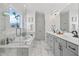 Elegant bathroom with a soaking tub, glass shower, dual sink vanity with marble countertops and floors at 204 Woodstaff Ave, Wake Forest, NC 27587