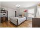Cozy bedroom featuring hardwood floors, a tufted headboard, and a sunlit window at 204 Woodstaff Ave, Wake Forest, NC 27587