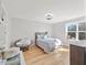 Sunlit bedroom with hardwood floors and a cozy seating area, enhanced by a large window at 204 Woodstaff Ave, Wake Forest, NC 27587