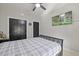 Bright bedroom with a tv, two closets and gray/black patterned bedding at 204 Woodstaff Ave, Wake Forest, NC 27587