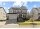 Inviting two-story home featuring a covered front porch and lush green lawn under a bright blue sky at 204 Woodstaff Ave, Wake Forest, NC 27587