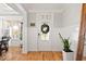 Bright foyer with hardwood floors, white wainscoting, and a stylish front door at 204 Woodstaff Ave, Wake Forest, NC 27587