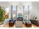 Open living area with tall ceilings, large windows, modern furnishings, and a sleek fireplace at 204 Woodstaff Ave, Wake Forest, NC 27587