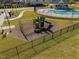 Close-up view of a community playground with slides and climbing structures, fenced for safety at 204 Woodstaff Ave, Wake Forest, NC 27587