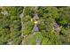 Drone's-eye view of the home nestled among mature trees in a serene neighborhood at 207 Old Forest Creek Dr, Chapel Hill, NC 27514
