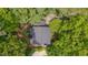 An aerial view of the home showing the roof surrounded by mature trees at 207 Old Forest Creek Dr, Chapel Hill, NC 27514