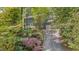 View of a lovely two-story home with lush landscaping, mature trees, and a private driveway at 207 Old Forest Creek Dr, Chapel Hill, NC 27514