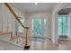 Bright foyer featuring hardwood floors, a staircase, and a view of the front entrance at 207 Old Forest Creek Dr, Chapel Hill, NC 27514