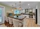 Bright kitchen featuring a large island with barstool seating and modern pendant lighting at 207 Old Forest Creek Dr, Chapel Hill, NC 27514