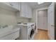 Convenient laundry room with washer, dryer, storage cabinets, and a utility sink at 207 Old Forest Creek Dr, Chapel Hill, NC 27514