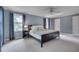 Bright main bedroom with a ceiling fan, carpet, and multiple windows with backyard view at 207 Old Forest Creek Dr, Chapel Hill, NC 27514