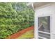 Side view of house with green evergreens, red mulch, and enclosed screened-in porch at 2073 Weston Green Loop, Cary, NC 27513