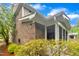 Brick home exterior featuring a screened-in porch and well-maintained landscaping at 2073 Weston Green Loop, Cary, NC 27513