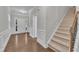 Welcoming foyer with hardwood floors, staircase, and white wainscoting at 2073 Weston Green Loop, Cary, NC 27513