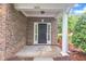 Inviting front porch of a brick townhome with a black front door and white trim at 2073 Weston Green Loop, Cary, NC 27513