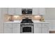 Modern kitchen features stainless steel range, backsplash, and white countertops at 2073 Weston Green Loop, Cary, NC 27513