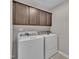 Laundry room with washer, dryer, and overhead cabinets at 2073 Weston Green Loop, Cary, NC 27513
