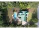 Aerial view of home with a green roof, pool with wood deck, lush trees, and circular driveway at 213 Birch Creek Dr, Fuquay Varina, NC 27526