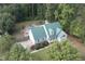 Aerial view of home showcasing a pool, mature trees, and green metal roof at 213 Birch Creek Dr, Fuquay Varina, NC 27526