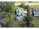 Aerial view of a home with a green roof and in-ground pool, surrounded by trees and green lawns at 213 Birch Creek Dr, Fuquay Varina, NC 27526