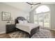 This primary bedroom features a large arched window, neutral colors, and an elegant ceiling fan at 213 Birch Creek Dr, Fuquay Varina, NC 27526