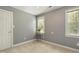 Neutral bedroom featuring a window, plant stand, light gray walls, and tan carpet at 213 Birch Creek Dr, Fuquay Varina, NC 27526