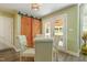 This breakfast nook offers a sliding barn door, and lots of natural light from the back patio doors and arched window at 213 Birch Creek Dr, Fuquay Varina, NC 27526