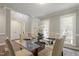 Bright dining room with a glass-topped table, seating for six, and lots of natural light from the large windows at 213 Birch Creek Dr, Fuquay Varina, NC 27526