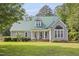 Charming home with a well-manicured lawn, a welcoming porch, and a distinctive green metal roof at 213 Birch Creek Dr, Fuquay Varina, NC 27526