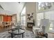 Bright living room boasts vaulted ceilings, large windows, a stone fireplace, and stylish furnishings at 213 Birch Creek Dr, Fuquay Varina, NC 27526