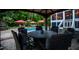 Charming outdoor dining area with a fire pit table, surrounded by the pool, patio and lush landscape at 213 Birch Creek Dr, Fuquay Varina, NC 27526
