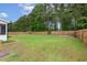 Large, fenced backyard with mature trees and a swing set, offering ample space for outdoor activities and gardening at 22 Chapman Ct, Wendell, NC 27591