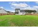Large, level backyard featuring a green lawn, a screened porch, and manicured landscaping, great for relaxation at 22 Chapman Ct, Wendell, NC 27591