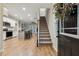 Inviting foyer with hardwood floors, staircase, and an open view of the modern kitchen and living space at 22 Chapman Ct, Wendell, NC 27591