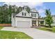 Charming white home featuring an attached garage, a welcoming front porch, and a spacious driveway at 22 Chapman Ct, Wendell, NC 27591