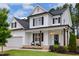 Charming two-story white home featuring black shutters, a covered front porch, and a well-manicured lawn at 22 Chapman Ct, Wendell, NC 27591