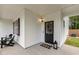 Charming front porch with a welcoming front door and black Adirondack chairs in front of the exterior window at 22 Chapman Ct, Wendell, NC 27591