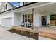 Inviting front porch with seating, brick accents, dark stained pillars, and stylish decor near the front door at 22 Chapman Ct, Wendell, NC 27591